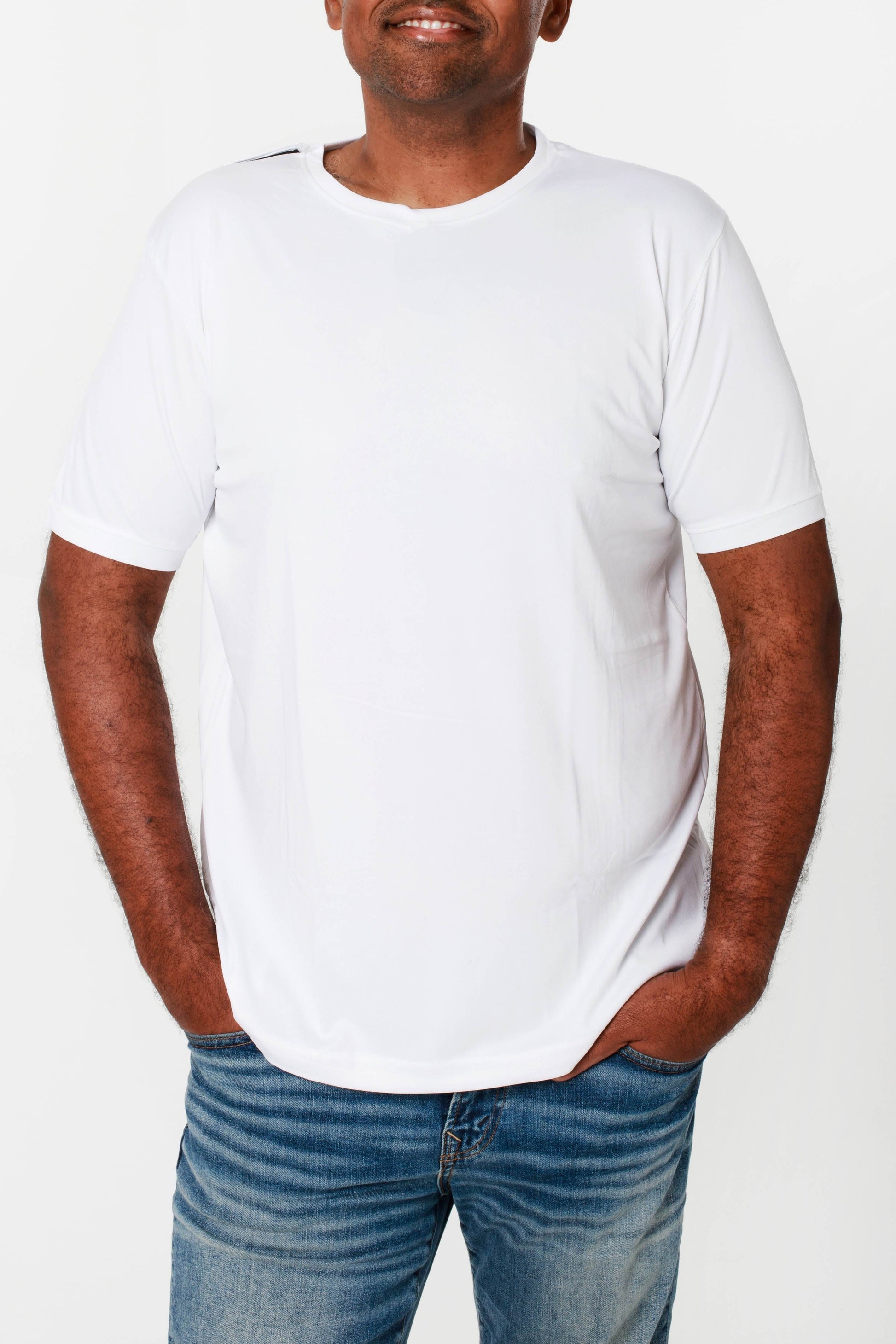 A man wearing a white round neck t-shirt with an open back design, paired with blue jeans.